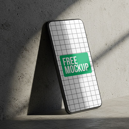 Free Smartphone PSD Mockup Leaning on Concrete — Gritty Tech PSD mockup for Adobe Photoshop